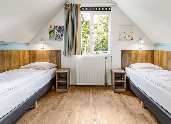 Sfeervolle woonkamer met houtkachel in Miggelenberg 8-persoons bungalow 8C, Hoenderloo, Veluwe.