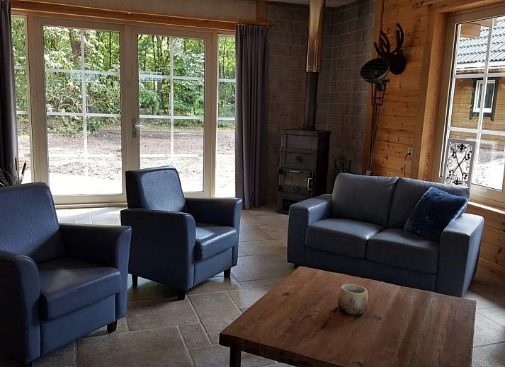 Groepsaccommodatie Bosuil in Hoenderloo, Veluwe, vakantiehuis met terras onder de bomen.