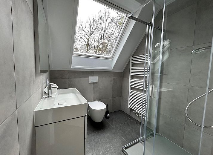 Attraktives Schlafzimmer in der Gruppenunterkunft Douglas, einem Ferienhaus in Hoenderloo in der Veluwe, Gelderland mit Blick auf die Natur.