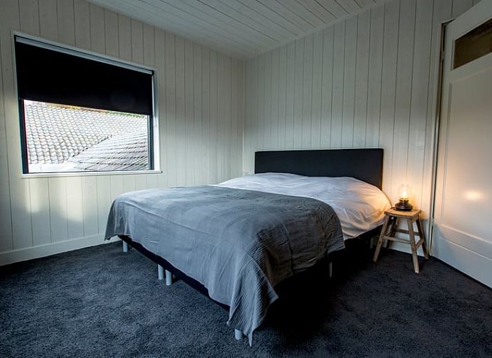 Sfeervolle slaapkamer in Huisje in Hoenderloo, Veluwe, met rustieke elementen.