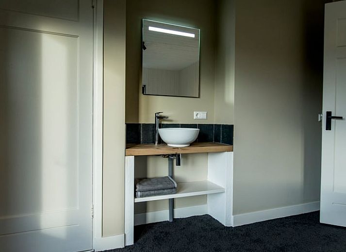 Sfeervolle slaapkamer in Huisje in Hoenderloo, Veluwe, met rustieke elementen.