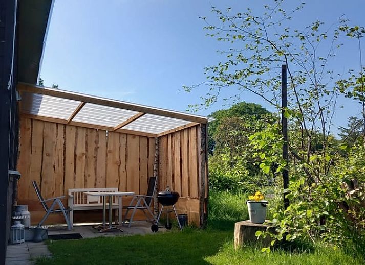 Ferienhaus in Garderen, umgeben von gruener Natur in der Veluwe, Gelderland, mit einer einladenden Terrasse zum Entspannen.