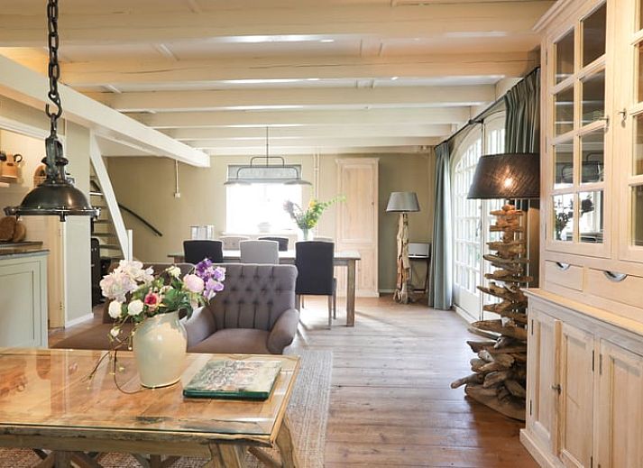 Terrasse des Ferienhauses in Garderen, Ferienunterkunft in der Veluwe, Gelderland, mit Sitzecke und natuerlicher Umgebung.