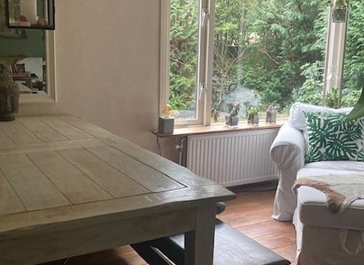 Knusse binnenruimte van Vakantiehuisje in Garderen met comfortabele zithoek en winterse Veluwe-omgeving.