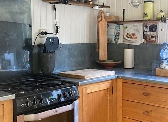 Knusse binnenruimte van Vakantiehuisje in Garderen met comfortabele zithoek en winterse Veluwe-omgeving.