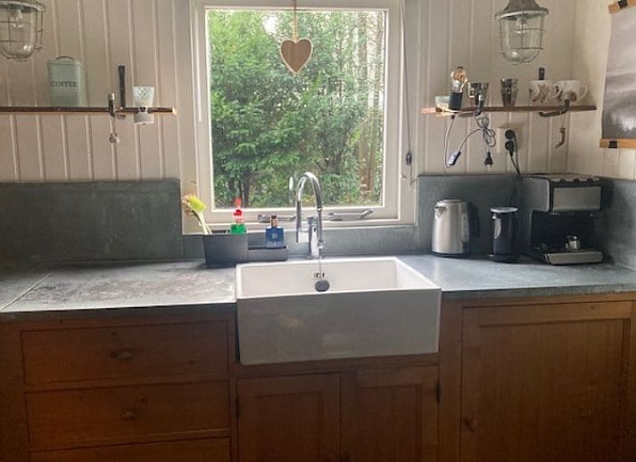 Knusse binnenruimte van Vakantiehuisje in Garderen met comfortabele zithoek en winterse Veluwe-omgeving.