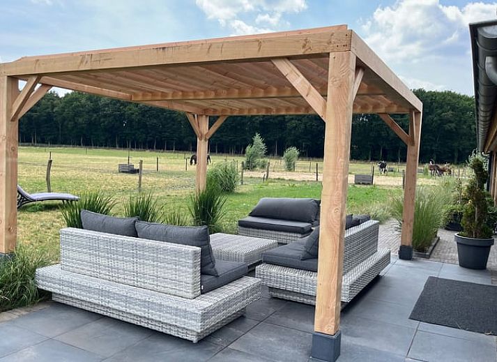 Geniet van de veranda bij Vakantiehuisje in Garderen, Veluwe, met uitzicht op de groene omgeving.