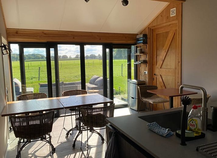 Moderne buitenruimte van Vakantiehuisje in Garderen, Veluwe, met veel glas voor een panoramisch uitzicht.