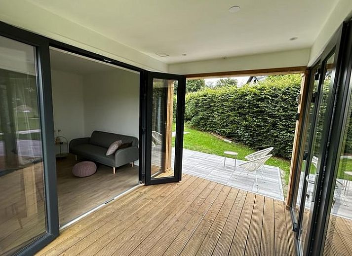 Modern wooden Cottage in Elspeet in the Veluwe region of Gelderland, surrounded by green grass.