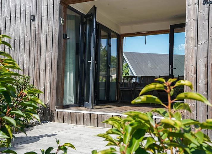 Modern wooden Cottage in Elspeet in the Veluwe region of Gelderland, surrounded by green grass.
