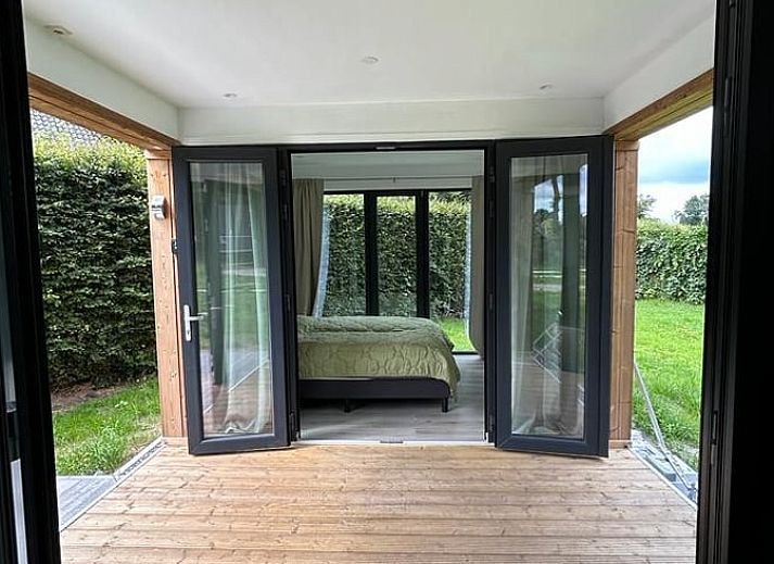 Spacious veranda of cottage in Elspeet overlooking green garden, Veluwe, Gelderland.