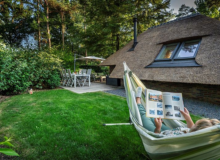 Cozy outdoor area of Vakantiewoning Sprielderbosch 5 De Bosuil in Putten, Veluwe with open doors to the inside.