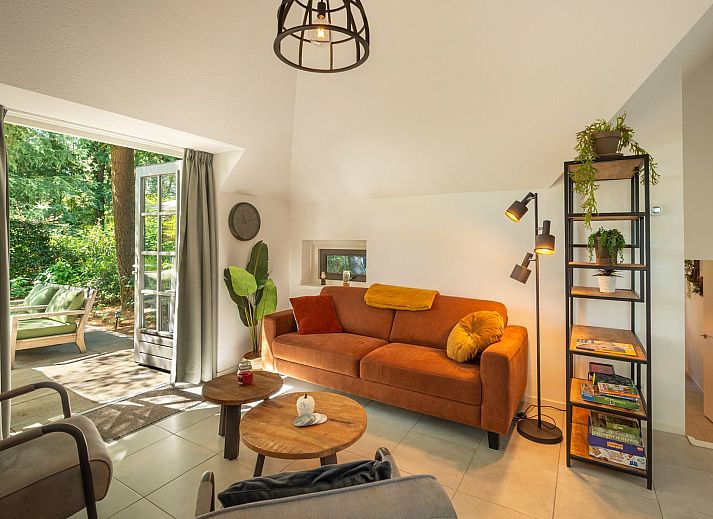 Cozy outdoor area of Vakantiewoning Sprielderbosch 5 De Bosuil in Putten, Veluwe with open doors to the inside.