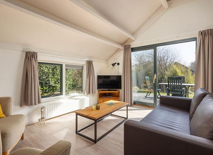 Gelderse Hoevewoning 4 in Putten, Veluwe, een charmante bungalow met rieten dak en zonnig terras, omringd door groene natuur.