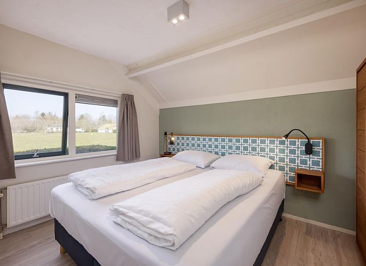 Gezellige woonkamer van Gelderse Hoevewoning 4 in Putten, Veluwe, met uitzicht op terras en groene omgeving.