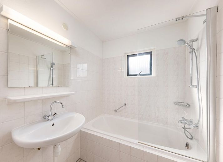 Gemuetliches Wohnzimmer des Bungalows Loghome 6 in Putten, Veluwe, mit Holzinterieur und Blick auf den gruenen Garten.