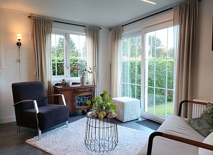 Cozy living room of DG1546 in Putten Veluwe with garden views and stylish decor.