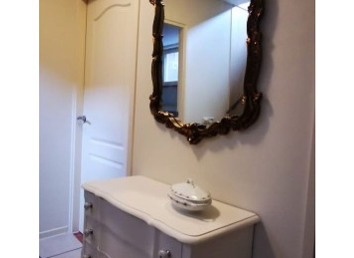 Garden of El Granero bungalow in Putten, Veluwe, with green fence and serene atmosphere.