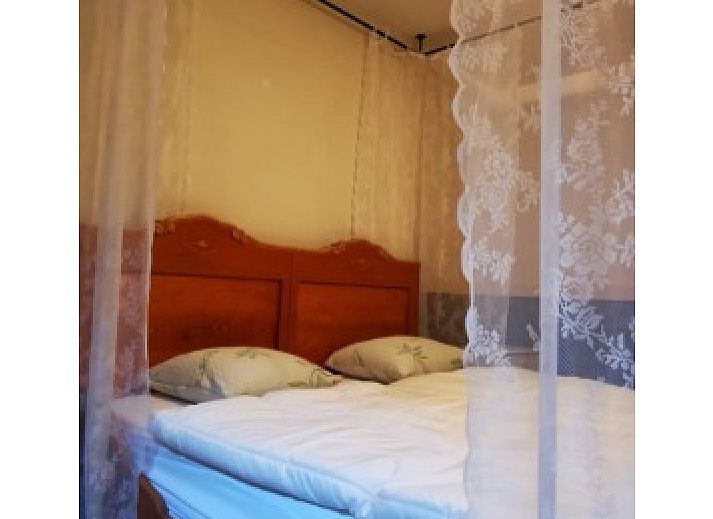 Garden of El Granero bungalow in Putten, Veluwe, with green fence and serene atmosphere.