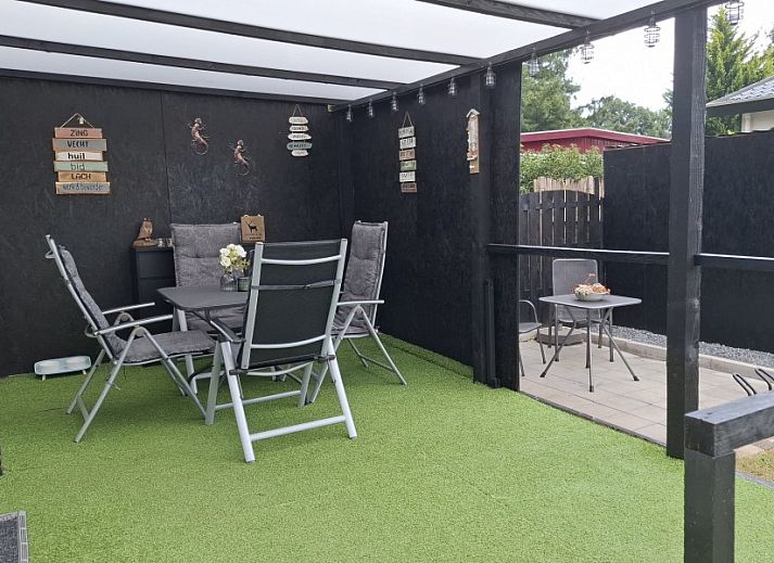 Chalet Relax in Putten, Veluwe, a cozy vacation home surrounded by green nature and equipped with a sunny terrace.