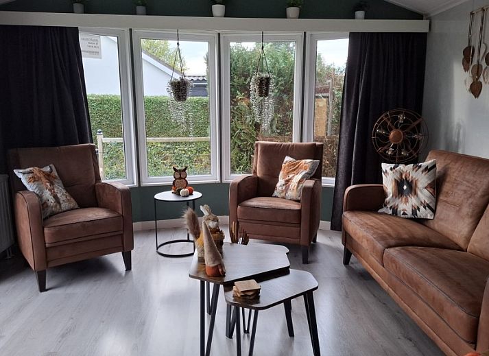 Covered porch of Chalet Relax in Putten, Veluwe, Gelderland, with comfortable seating area and views of the natural surroundings.