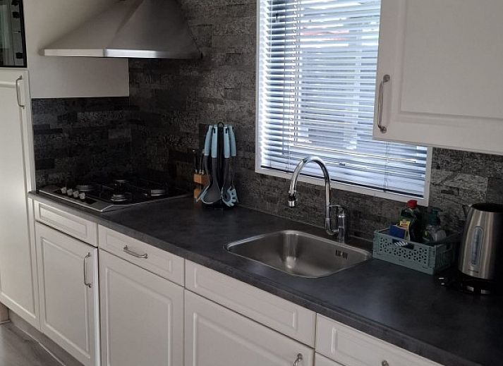 Covered porch of Chalet Relax in Putten, Veluwe, Gelderland, with comfortable seating area and views of the natural surroundings.