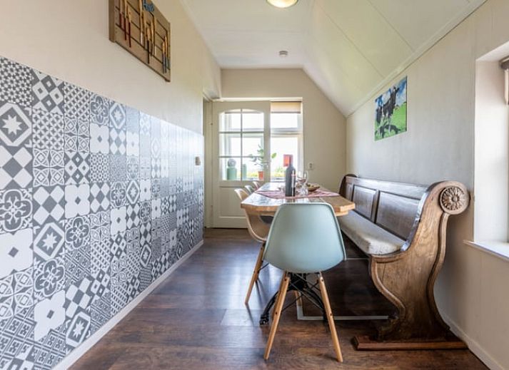 Dining area in Holiday Home in Wezep Oldebroek, Veluwe, Gelderland with spacious table and colorful chairs.