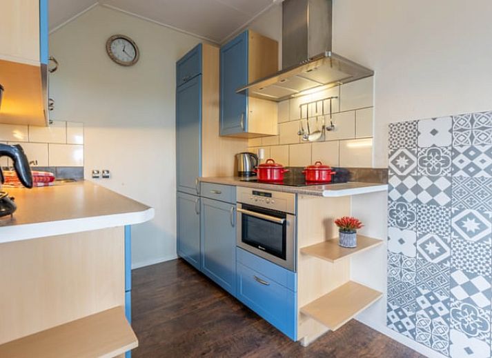 Dining area in Holiday Home in Wezep Oldebroek, Veluwe, Gelderland with spacious table and colorful chairs.
