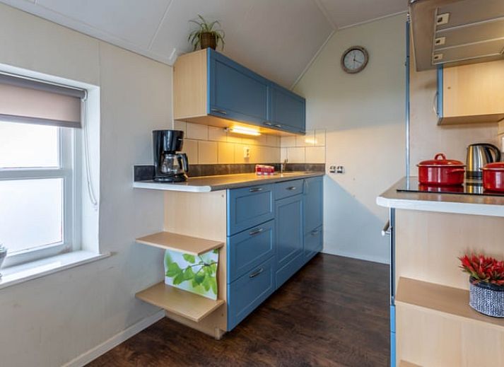 Dining area in Holiday Home in Wezep Oldebroek, Veluwe, Gelderland with spacious table and colorful chairs.
