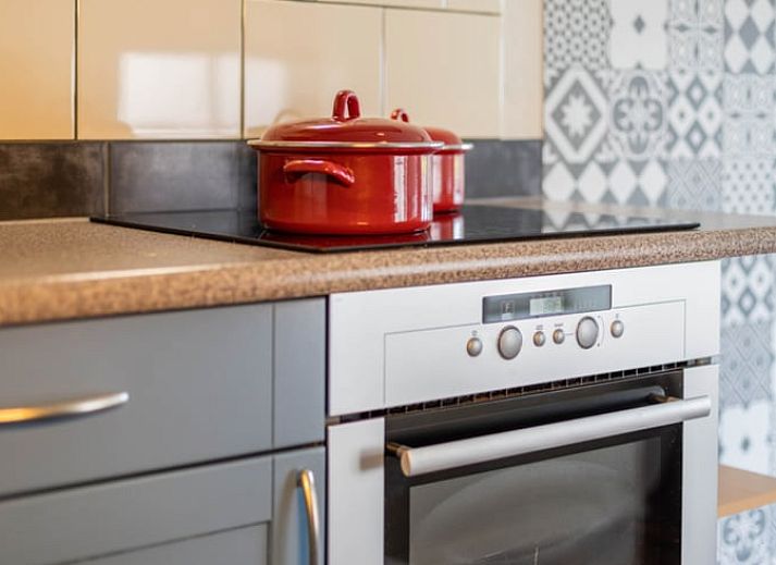 Dining area in Holiday Home in Wezep Oldebroek, Veluwe, Gelderland with spacious table and colorful chairs.
