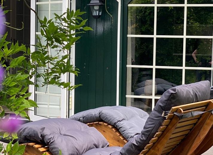 Indoor area of The Veluws Paradijs in Voorthuizen overlooking green garden and comfortable lounge area.