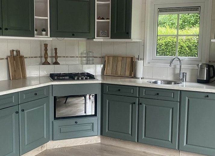 Indoor area of The Veluws Paradijs in Voorthuizen overlooking green garden and comfortable lounge area.