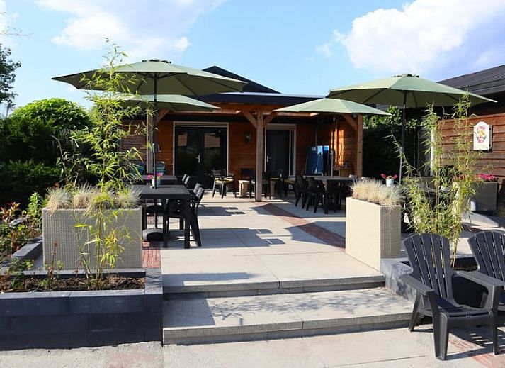 Vakantiehuis in Voorthuizen Veluwe met ruim terras en parasols voor ontspanning.