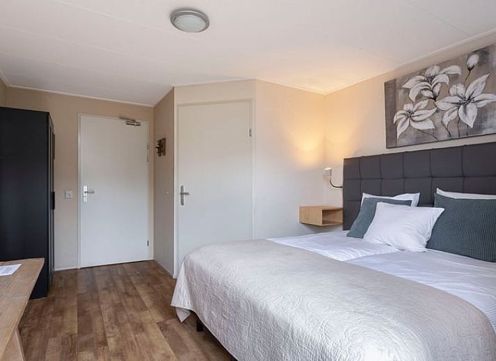 Gezellige eetruimte in Vakantiehuis in Voorthuizen Veluwe met houten tafels en stoelen.