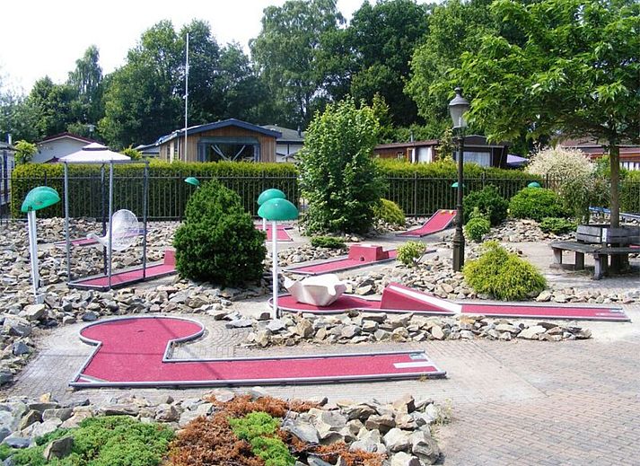 Veranda des Ferienhauses Recreatiepark De Boshoek in Voorthuizen, Veluwe mit Sonnenschirmen und Blick ins Gruene.