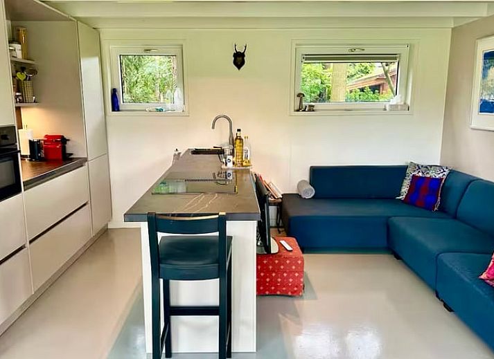 Gemuetliches Esszimmer im Ferienhaus in Voorthuizen, Veluwe, mit Blick auf die gruene Natur und stimmungsvollem Dekor.