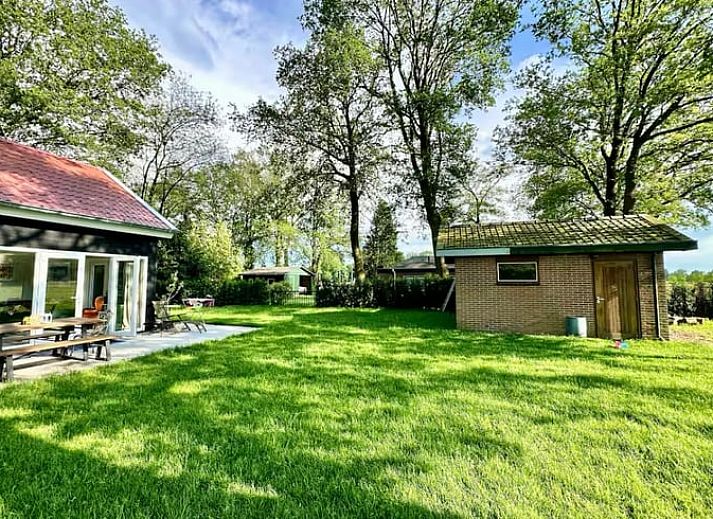 Ferienhaus in Voorthuizen, Veluwe, Gelderland, umgeben von gruener Natur und Baeumen, ein idealer Ort fuer Ruhe und Entspannung.