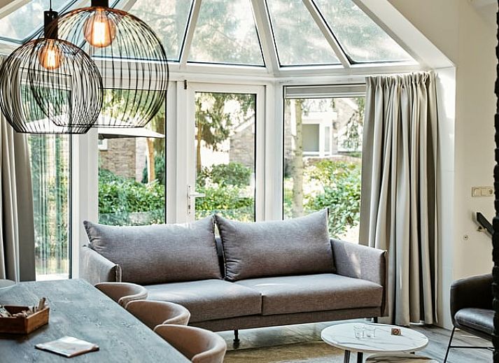 Gezellige zithoek met open haard in Vakantiehuis in Vaassen, Veluwe, Gelderland.