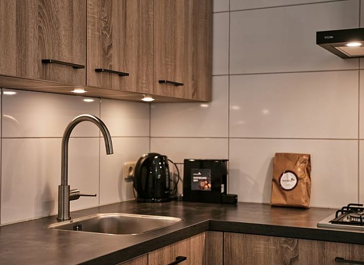 Lichte woonkamer met uitzicht op de tuin in Vakantiehuis in Vaassen, Veluwe, Gelderland.