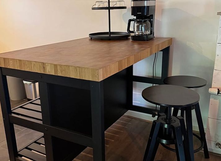 Esstisch mit Sonnenschirm im Garten des Ferienhauses in Vaassen, Veluwe, Gelderland.