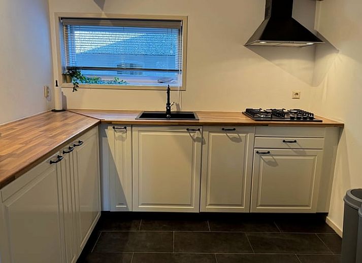 Esstisch mit Sonnenschirm im Garten des Ferienhauses in Vaassen, Veluwe, Gelderland.