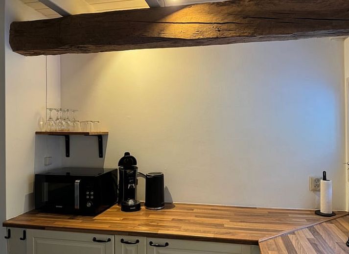 Esstisch mit Sonnenschirm im Garten des Ferienhauses in Vaassen, Veluwe, Gelderland.