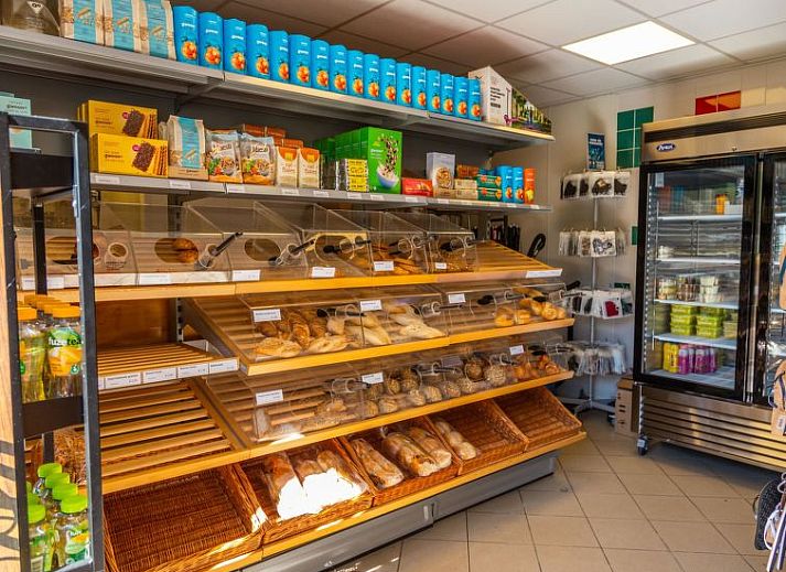 Comfortabele zithoek in Vakantiehuis Hackfort 6, Hulshorst, Veluwe met uitzicht op de natuur.