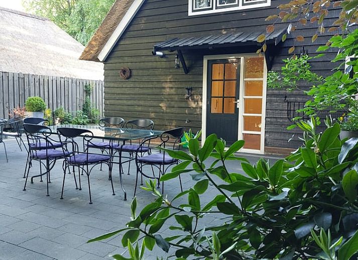 Charmante gevel van Vakantiehuisje in Hulshorst, Veluwe, Gelderland met grasveld en bomen.