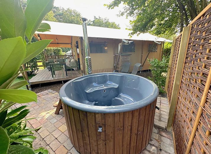 Geniet van luxe ontspanning bij tenthuis Libelle in Hulshorst, Veluwe, met een uitnodigende hot tub en ruime veranda in de natuur.