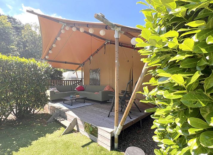 Geniet van luxe ontspanning bij tenthuis Libelle in Hulshorst, Veluwe, met een uitnodigende hot tub en ruime veranda in de natuur.