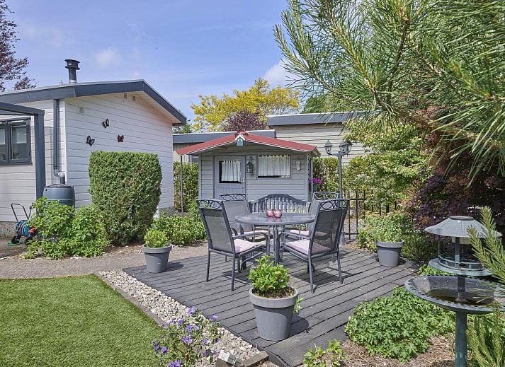 Geniet van de serene tuin en het terras bij vakantiehuis Kerkuil in Hulshorst, Veluwe, Gelderland.
