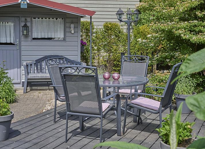 Rustieke buitenruimte van vakantiehuis Kerkuil in Hulshorst, Veluwe, met comfortabele zitplaatsen.