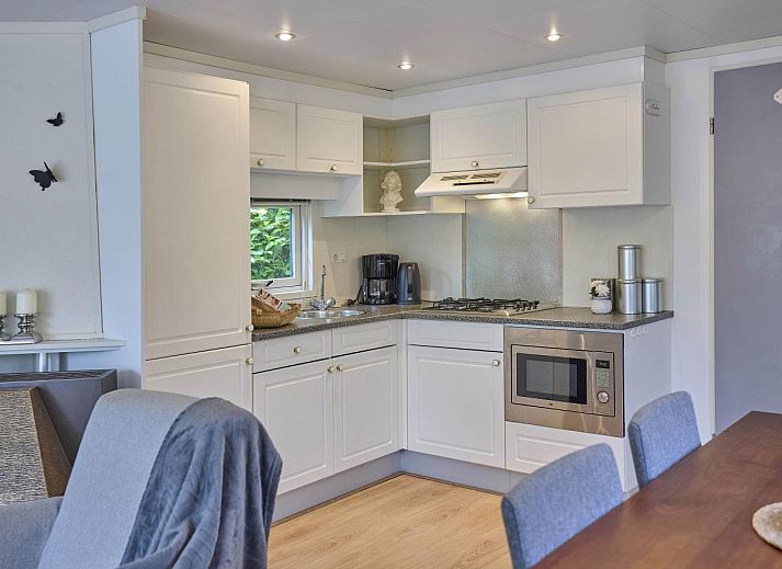 Charmante veranda van vakantiehuis Kerkuil in Hulshorst, Veluwe, met uitnodigende zitgelegenheid.