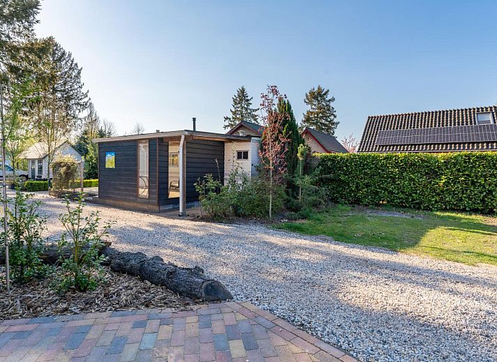 Dining area in chalet Eekhoorn, Hulshorst, Veluwe with wooden table and green chairs.